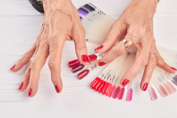 Old woman compares nail color with nail sample