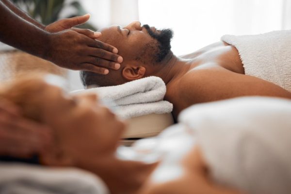 Relax man, head massage and couple on spa massage table for facial, wellness and stress relief ther
